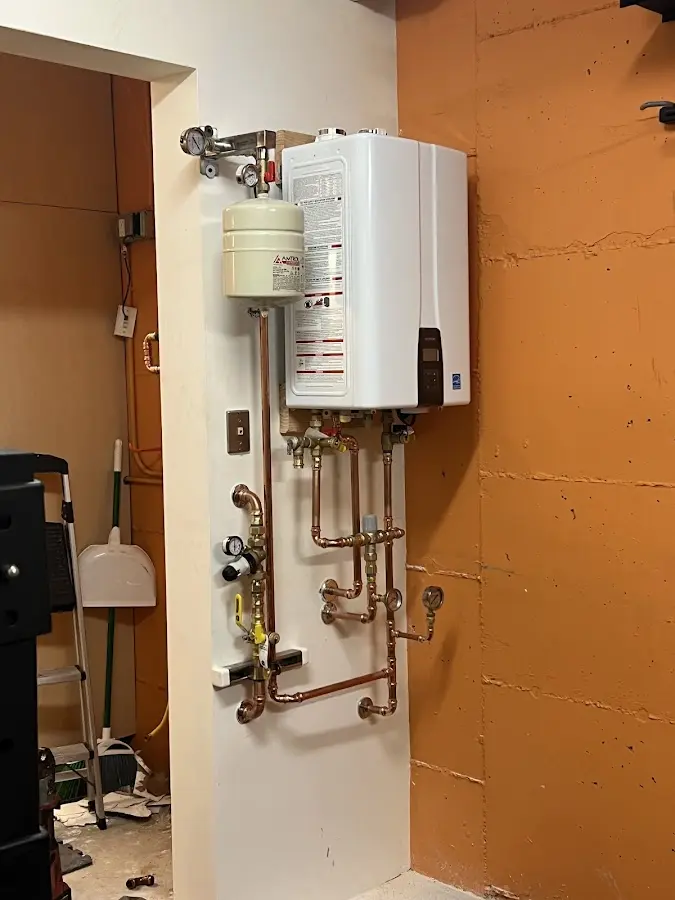 Plumbing technician inspecting water heater connections in Merrydale